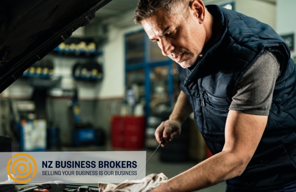 Mechanic checking engine oil in a vehicle workshop