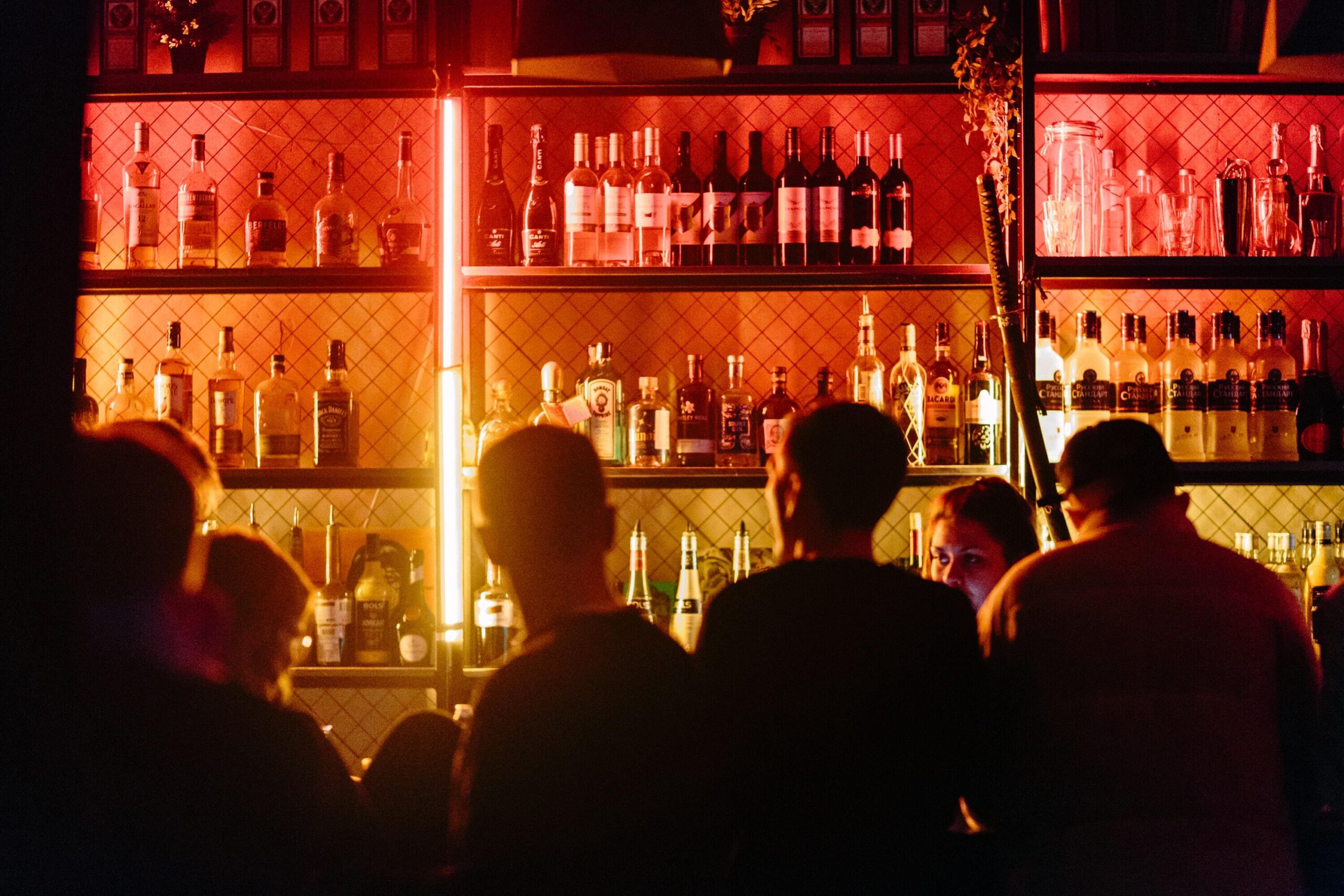 Busy Ponsonby bar with fully stocked back bar and ambient red lighting