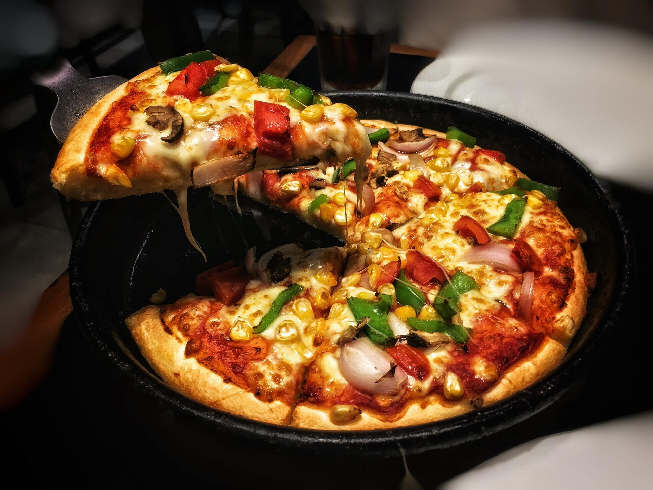 Freshly baked pizza with vegetables on a cast iron pan